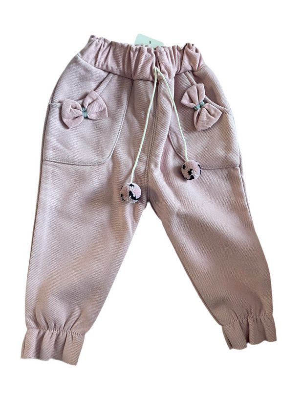 Pink fleece-lined toddler girl jogger pants with bows, pockets, and pom-pom drawstring ties